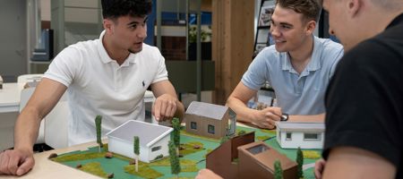 Studenten architectuur bij hun maquettes van huizen